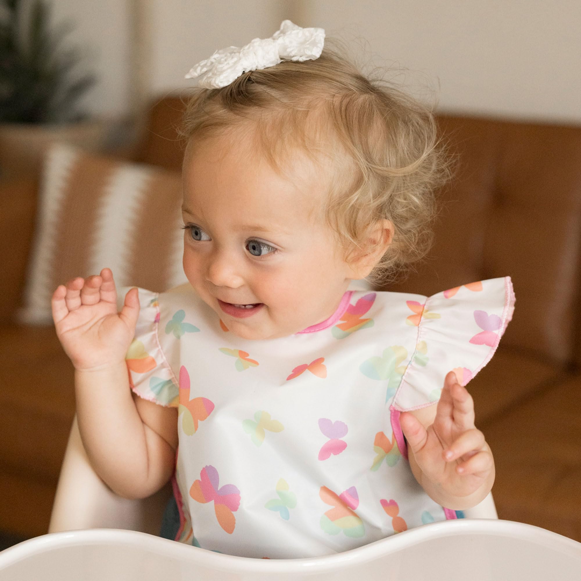 Tiny Twinkle mess-proof bib butterflies worn during mealtime in action demonstrates splash protection.