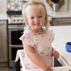 Tiny Twinkle mess-proof bib close-up highlights soft fabric and quick-clean surface.