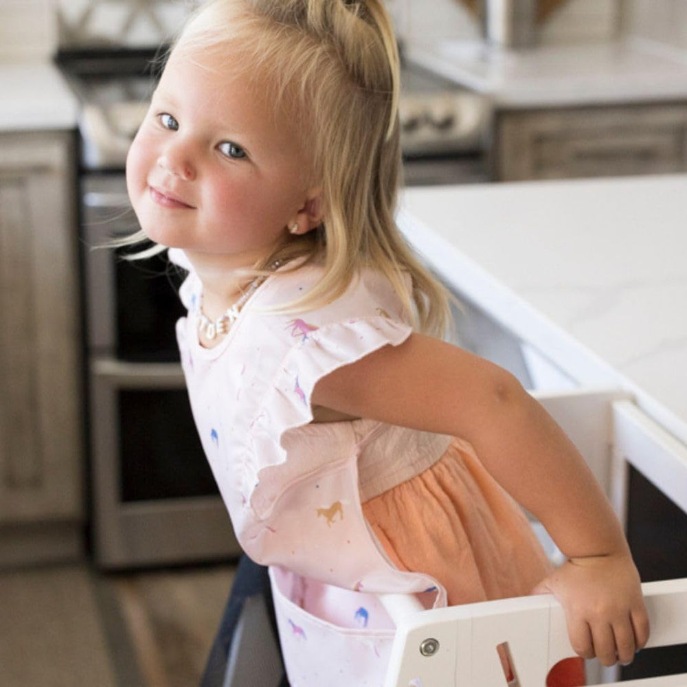 Tiny Twinkle bib pictured with washing machine symbol emphasizes machine-washable care.