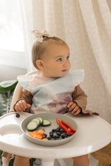 tiny twinkle mess proof bib waterproof back shows water-repellent layer during messy meals.