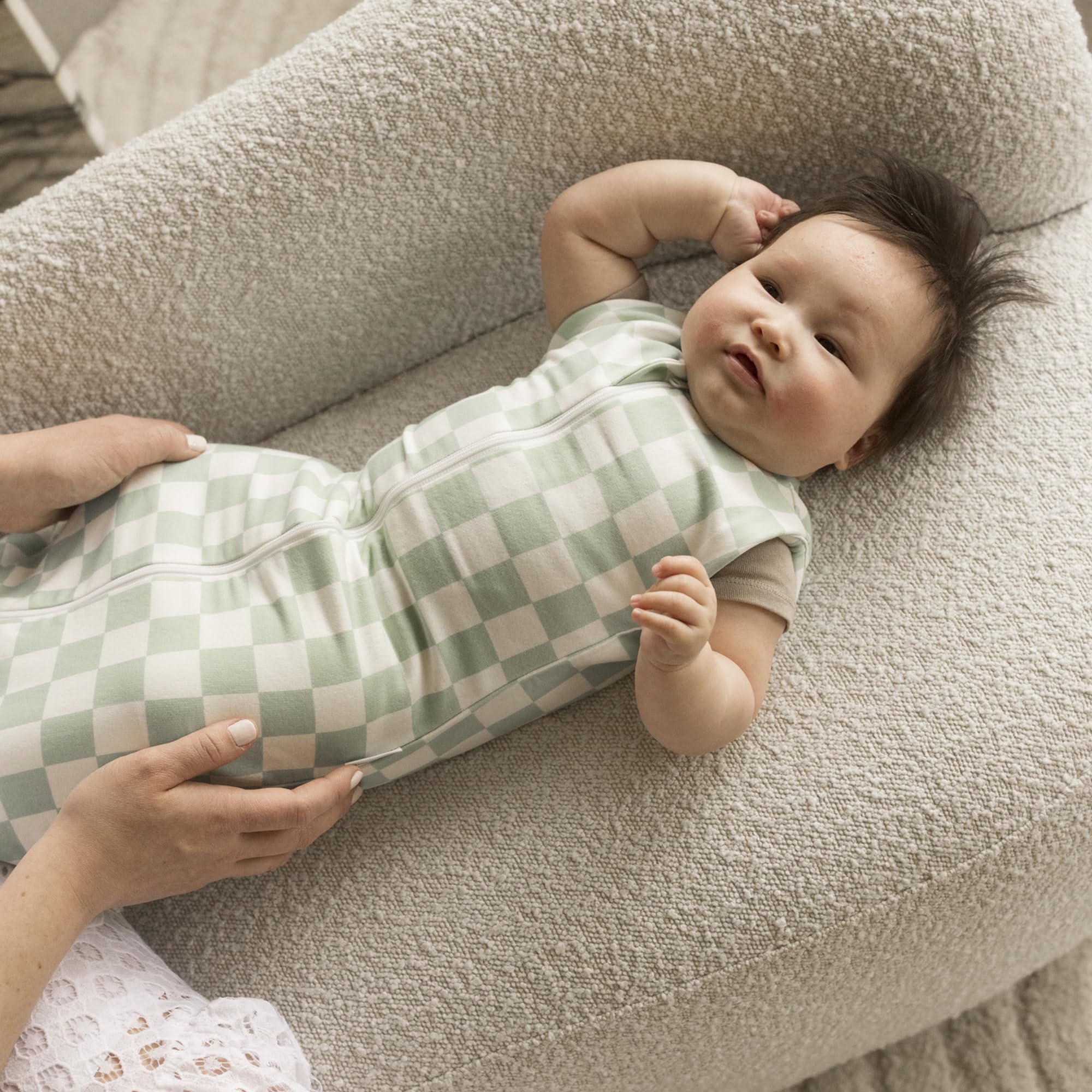 Tiny Twinkle sage checkers baby wearing the sleep sack for cozy sleep.