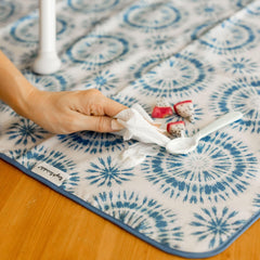 Tiny Twinkle Splat Mat being wiped clean after use.
