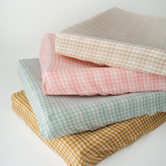 TISU Gingham diaper changing pad cover in pink-gingham for soft muslin comfort during changes.