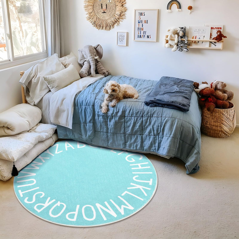 Topotdor teal alphabet rug used in a nursery for interactive learning