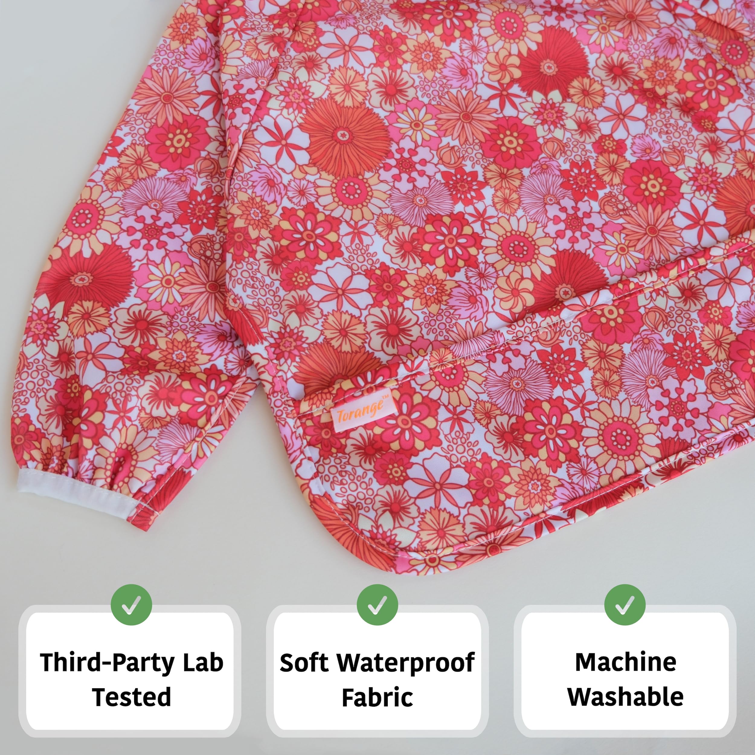 Torange smock bib elastic cuffs close-up demonstrates secure tug-proof fit.