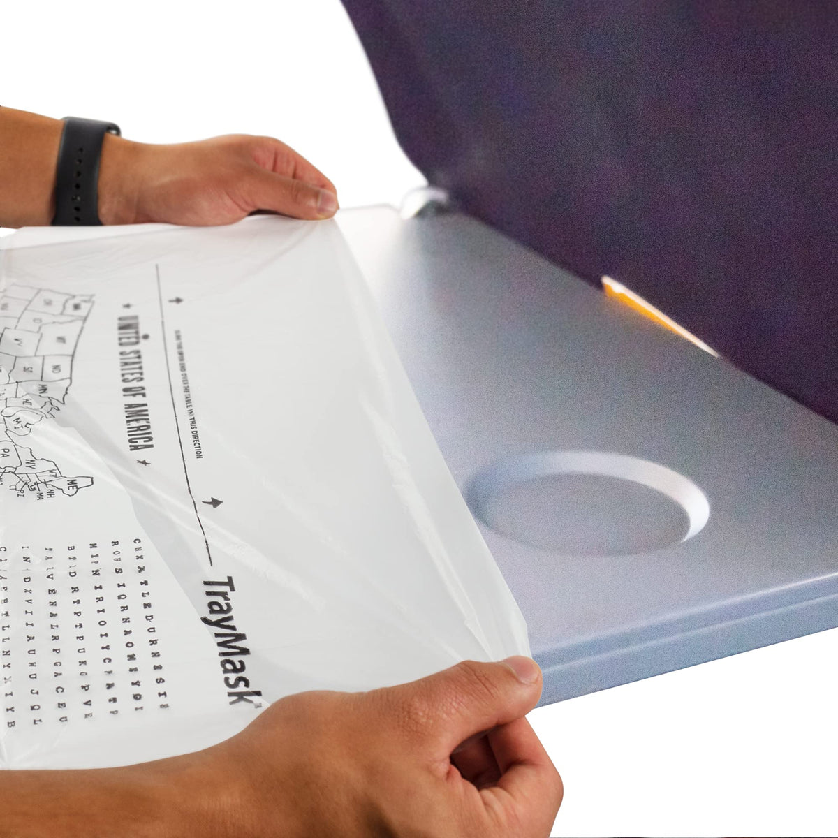 TrayMask disposable tray table cover on an airplane tray for a clean surface during travel.