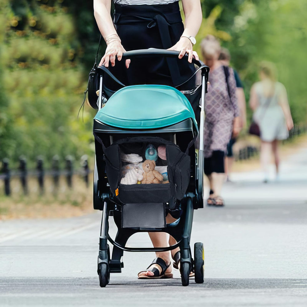 TRIPDAILY stroller organizer in use outdoors holds bottles, snacks, and toys.