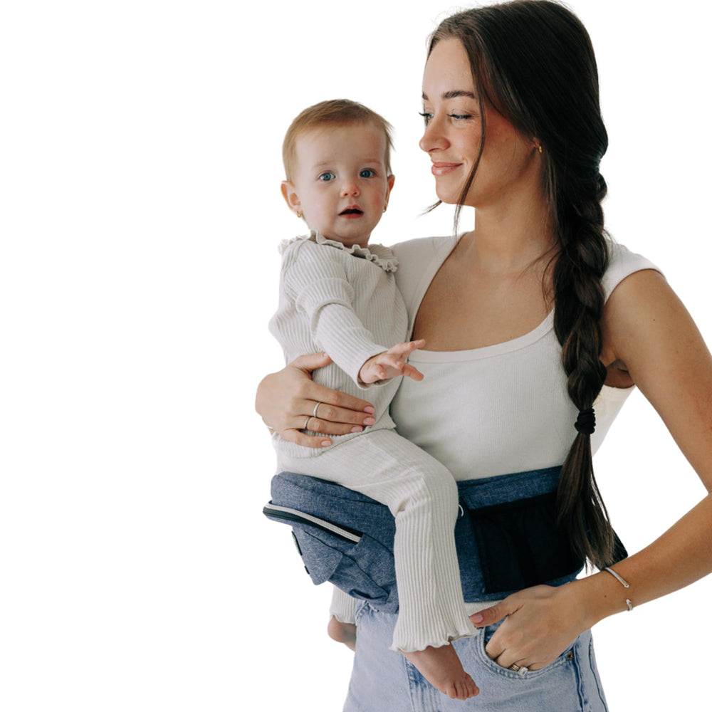 TushBaby hip-seat carrier buckle close-up shows secure hardware for confident carries.
