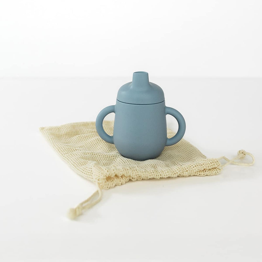 TushBaby Training Cup with easy-grip handle supports early self-feeding and coordination.