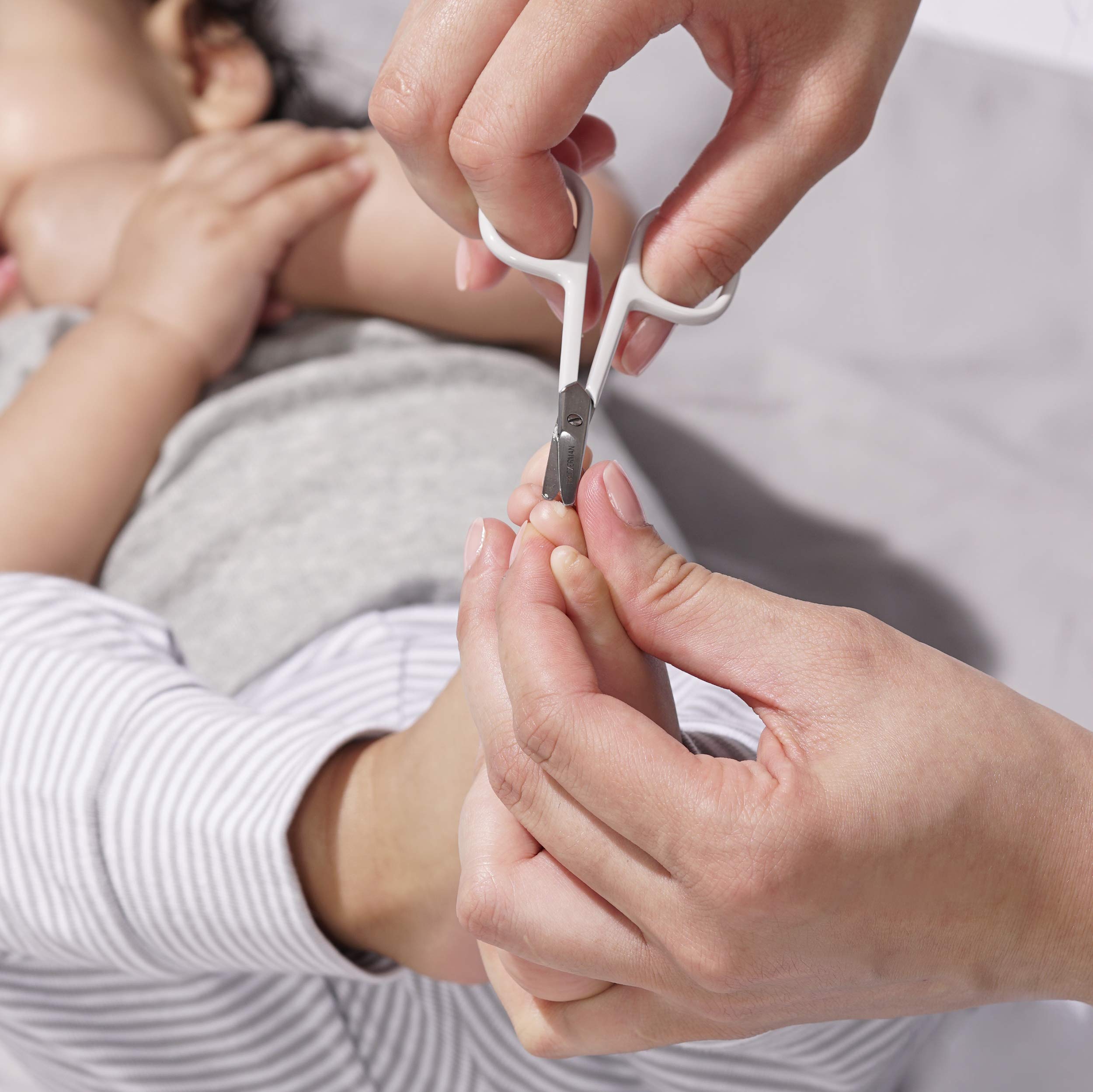 Tweezerman expert-trim hold-baby-hand image showing secure grip for safe trimming
