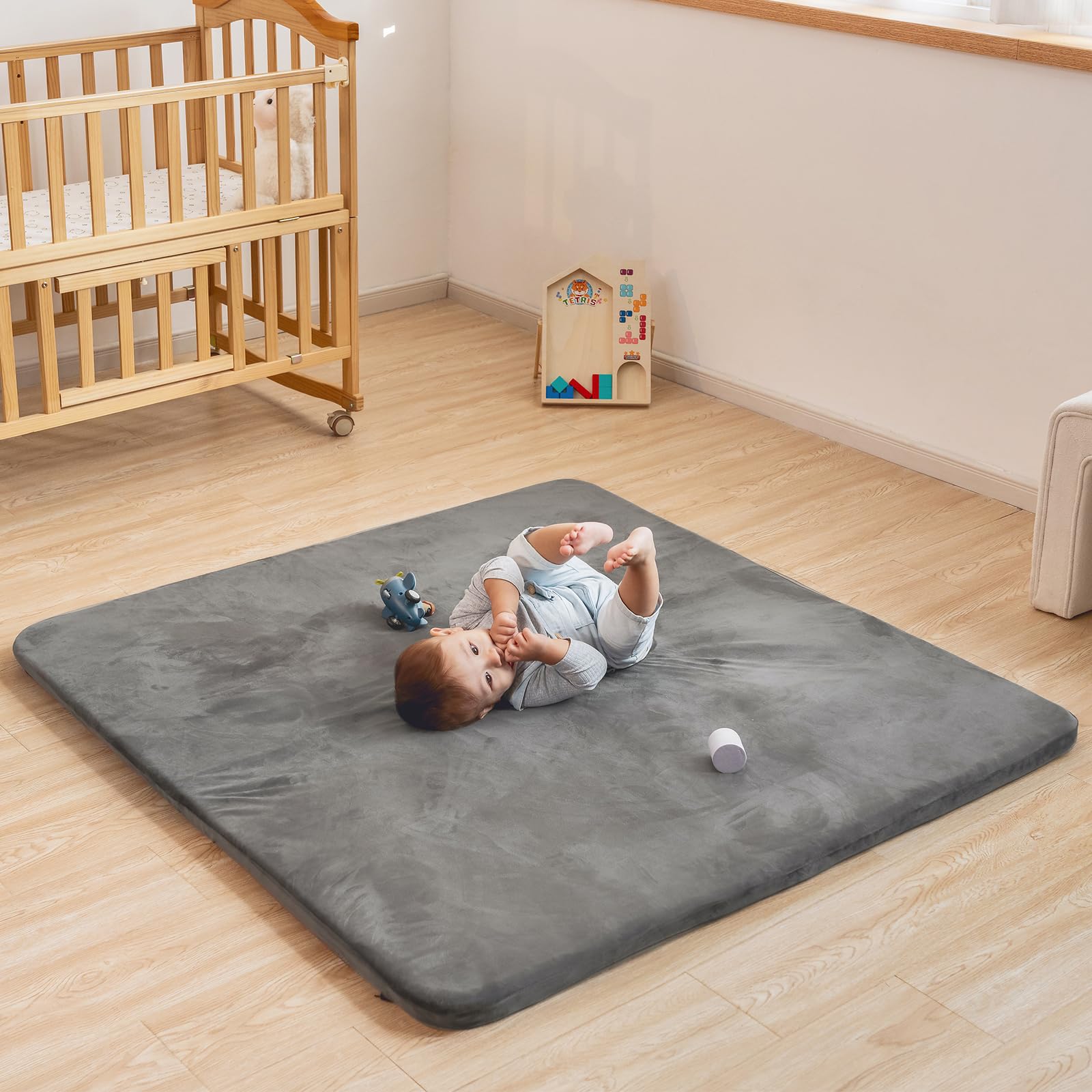 Uniency baby play mat used in living room with toddler crawling.