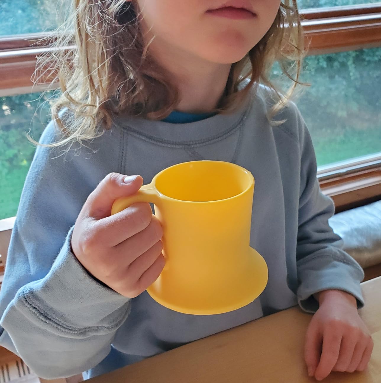 Untippy silicone toddler mug wide-base design reduces tipping on uneven tables.