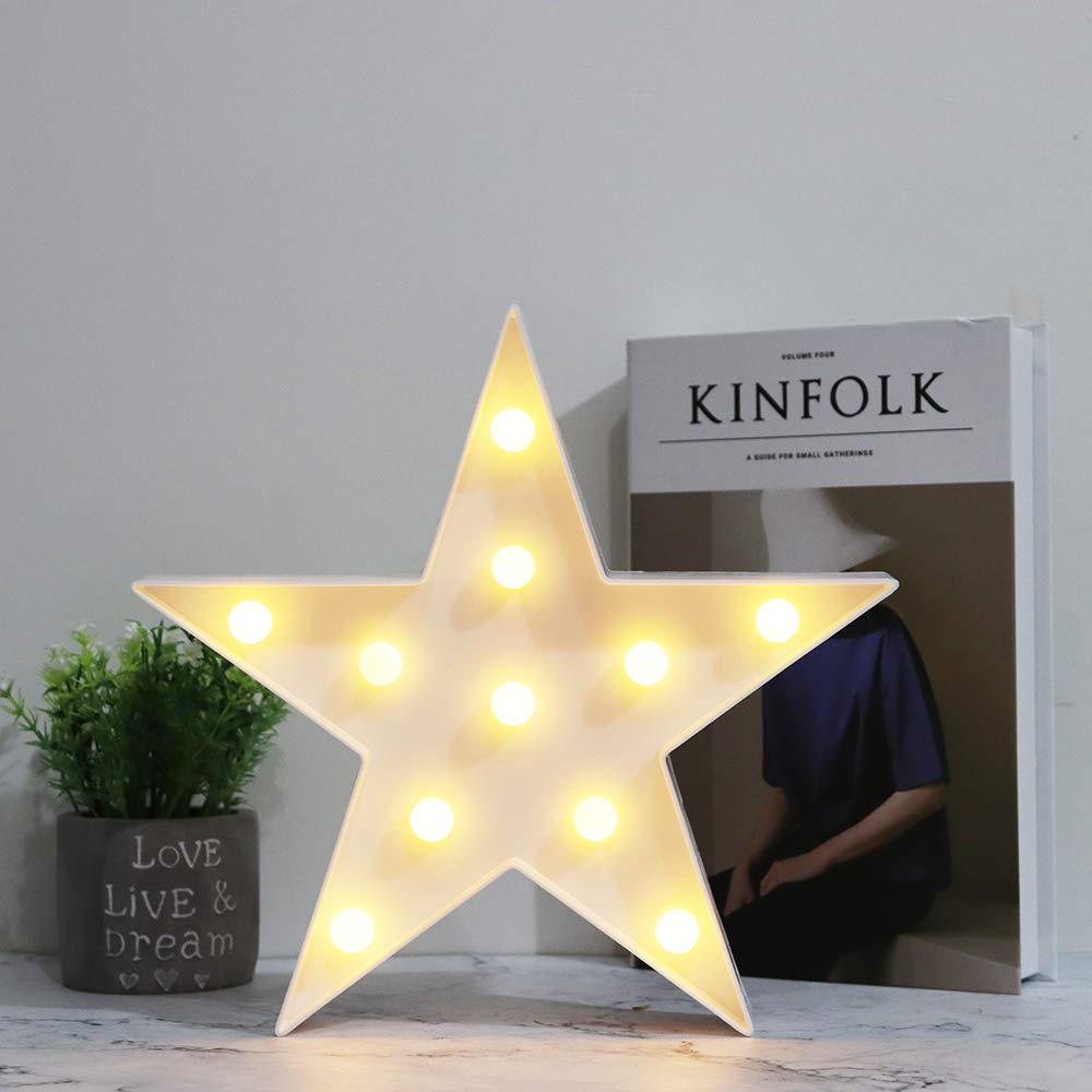Vicila star sign desk lamp in warm white on a bedside table.