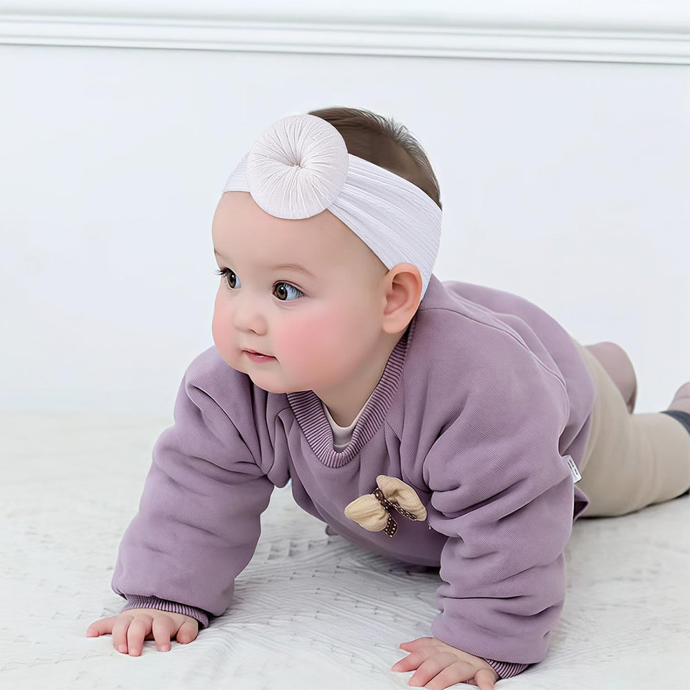 VISBL pom-pom bows—stretchy headbands ensuring secure fit during playtime