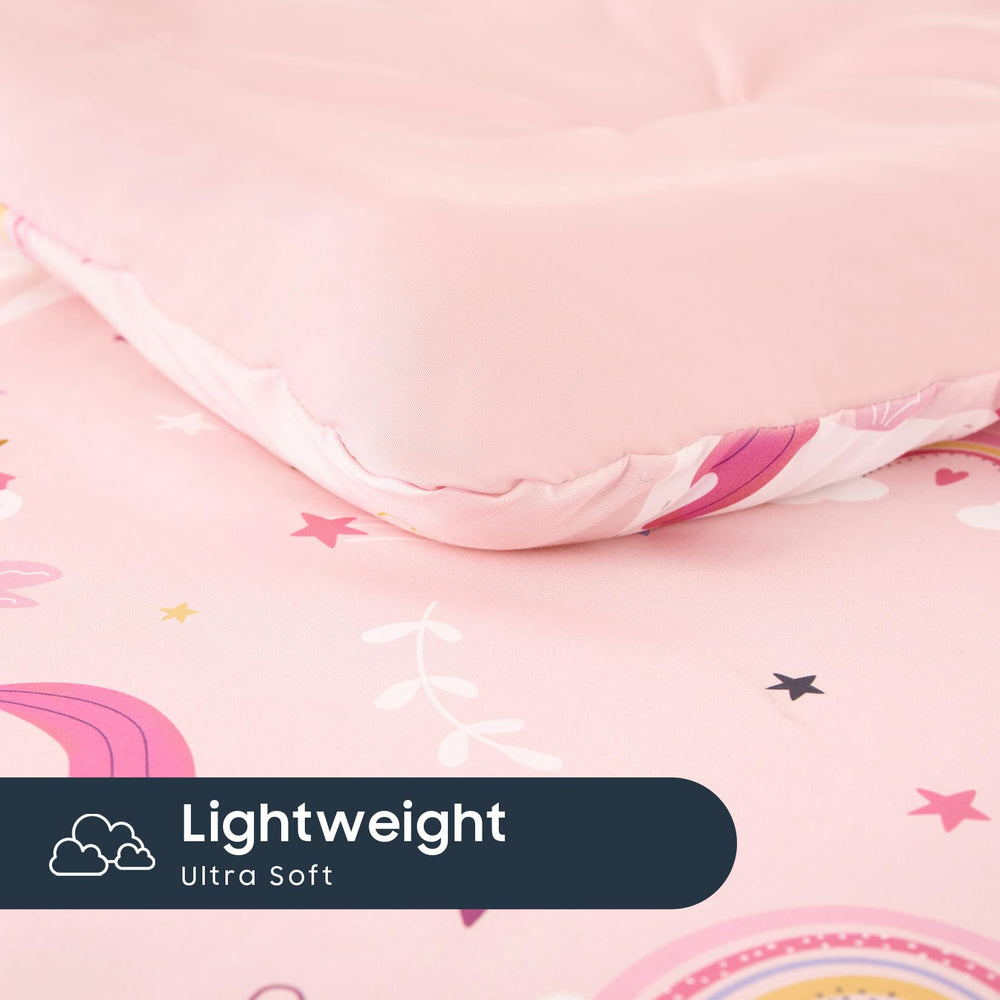 Wake In Cloud toddler bedding set pink shown on a cozy kids' bed.