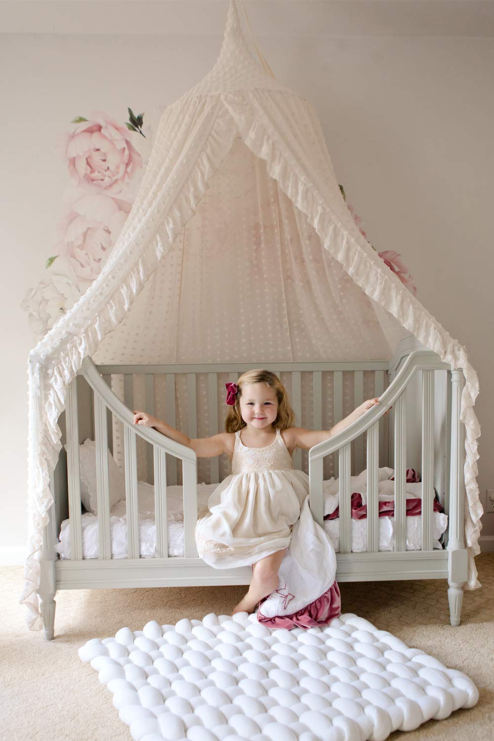 Wonder Space pom-detail beige canopy adds whimsical decor for imaginative play and nap time.