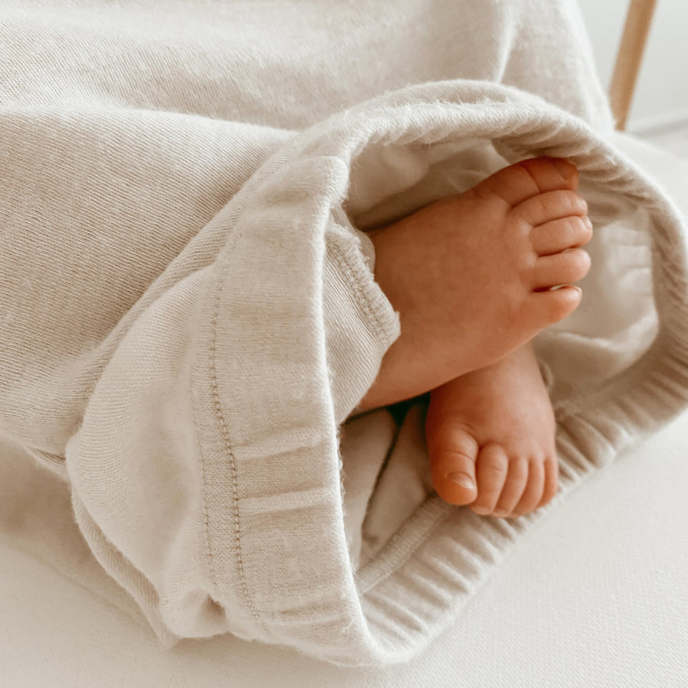 Woolino Infant Nightgown beige color worn by baby for year-round comfort.