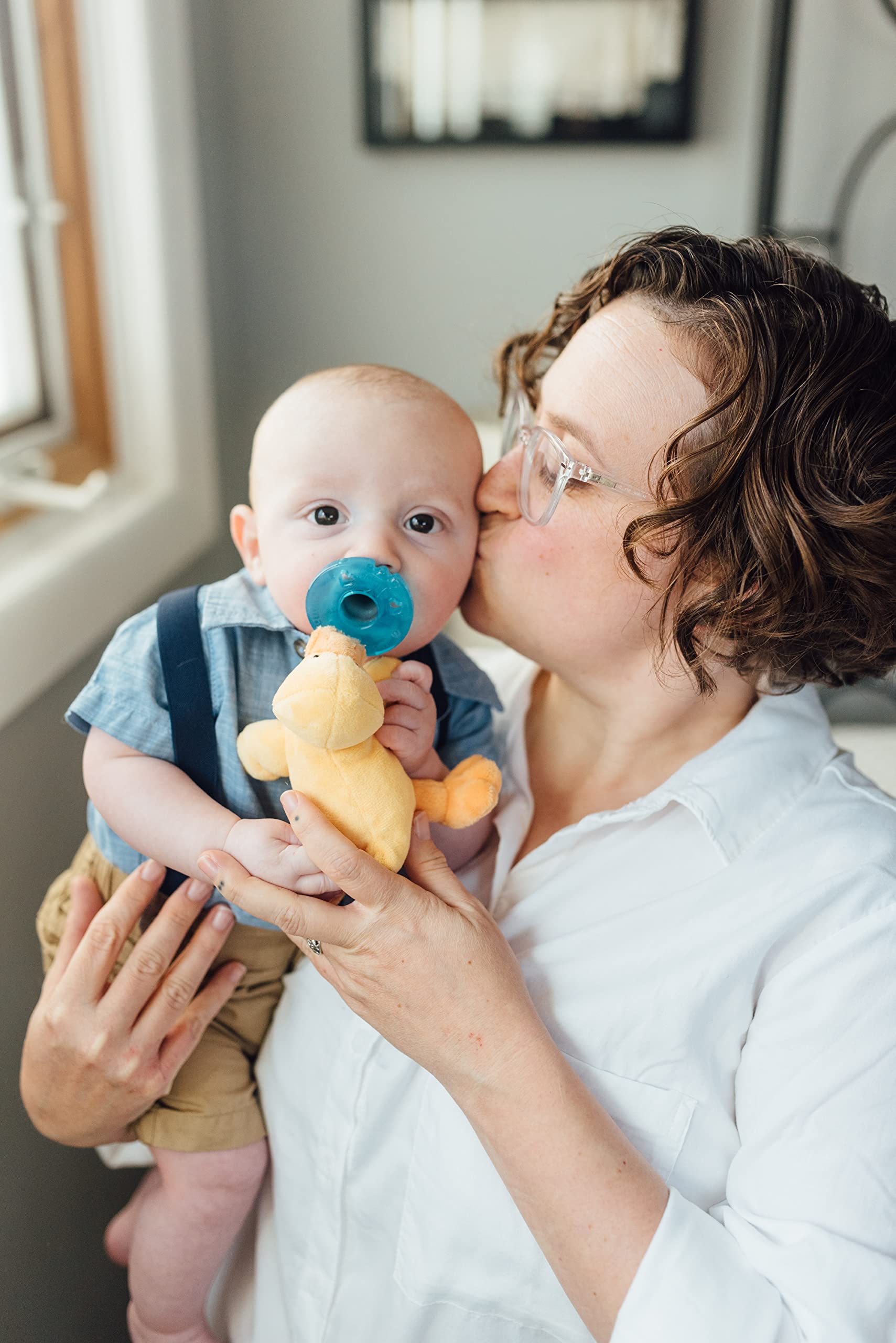 WubbaNub infant pacifier yellow duck in hands demonstrates portable comfort for on-the-go soothing