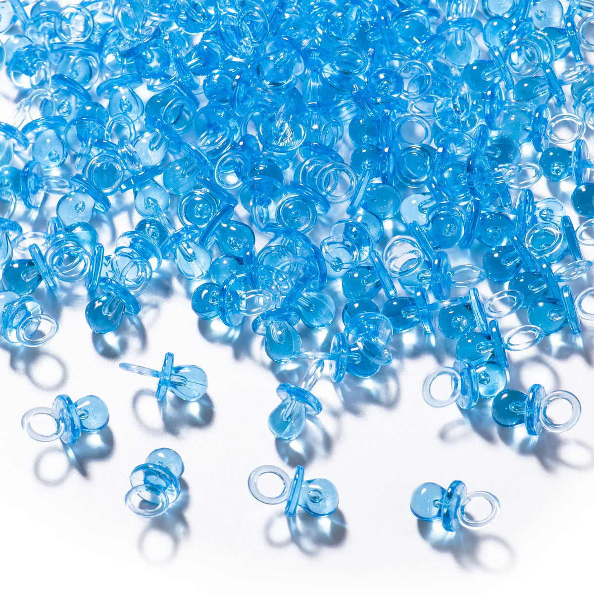 XINHUIDALSQ blue mini acrylic pacifiers scattered on a table for party decor