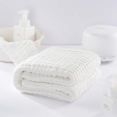 Yoofoss muslin cotton towel demonstrates absorbent surface for quick water pickup after baths.