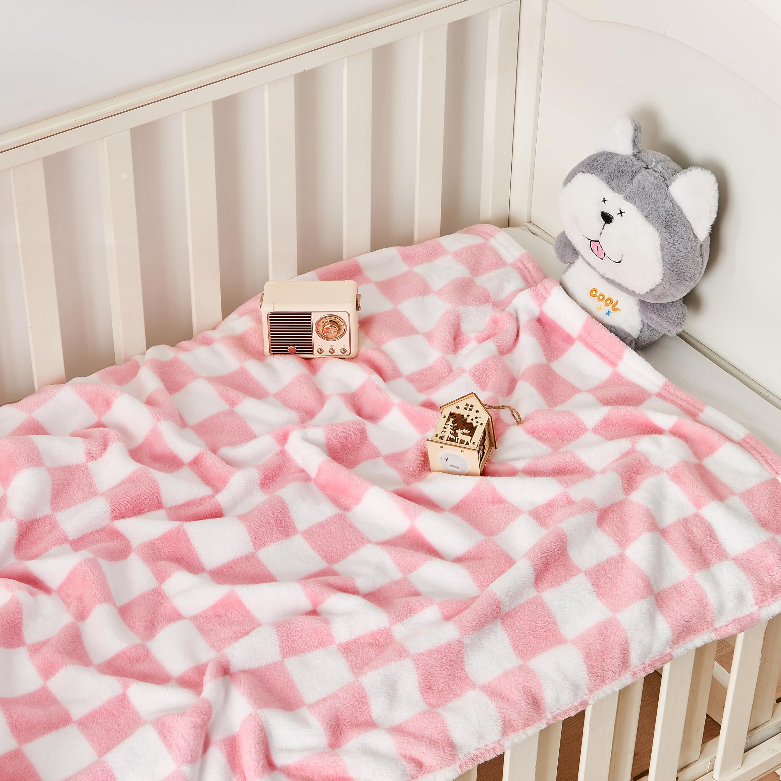 Yurhap pink checkered baby blanket laid flat on crib for cozy naps.