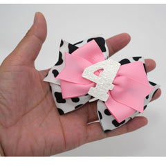 Zlwse cowprint cowgirl bow adds playful theme to birthday celebrations.